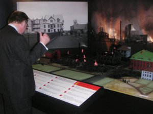 Mibjarbruninn.  upplsingabori fyrir framan lkani voru hnappar  
sem kveiktu ljs vi hvert hs sem brann og ar mtti lesa  
upplsingar um hsin. Lkani geru Sigurur Halldrsson  Mdelsmi  
og Bjrn r Bjrnsson hnnuur. Sningarhnnuur var Bjrn G.  
Bjrnsson. Smiir sningarinnar voru Sigurur Gumundsson og Trausti  
Sigursson. Lkani samt eldi og effektum, er n til snis   
rbjarsafni  gu sambli vi slkkvitki fyrri tma. Unni fyrir  
Landsbankann